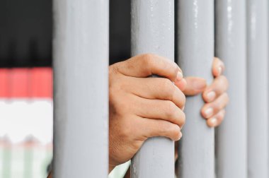 Siyah arka planda bir mahkumun elleri