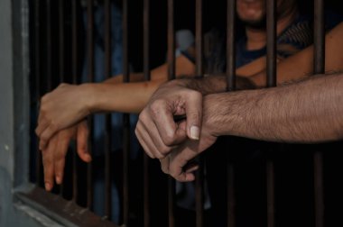 Siyah arka planda bir mahkumun elleri