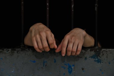 Siyah arka planda bir mahkumun elleri