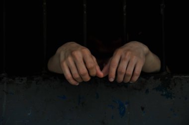 Siyah arka planda bir mahkumun elleri