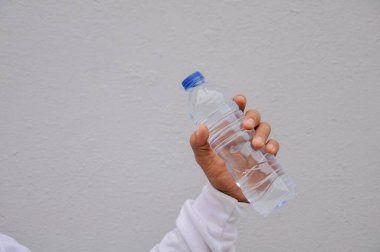 Plastik şişe tutan bir adam.