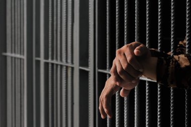 Siyah arka planda bir mahkumun elleri