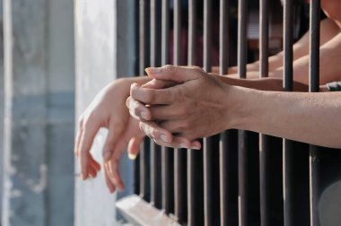 Siyah arka planda bir mahkumun elleri