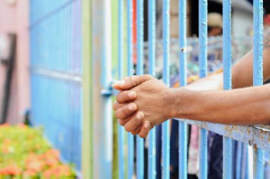 Siyah arka planda bir mahkumun elleri