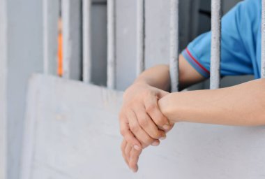 Siyah arka planda bir mahkumun elleri