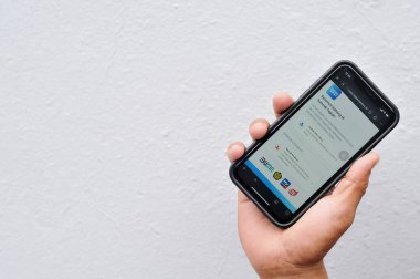 Bengkalis-Riau, 10 Kasım 2024: Sübvansiyonlu BBM uygulaması olan bir adamın eli cep telefonunu tutuyor