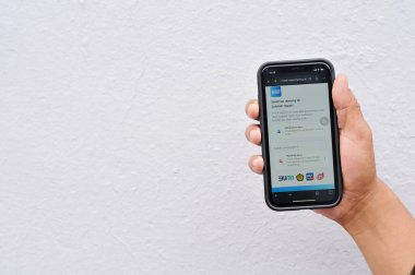 Bengkalis-Riau, 10 Kasım 2024: Sübvansiyonlu BBM uygulaması olan bir adamın eli cep telefonunu tutuyor