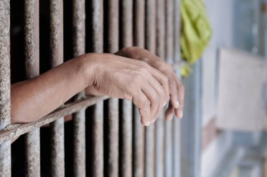 Siyah arka planda bir mahkumun elleri