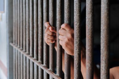 Siyah arka planda bir mahkumun elleri