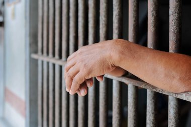 Siyah arka planda bir mahkumun elleri