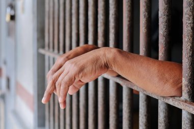 Siyah arka planda bir mahkumun elleri