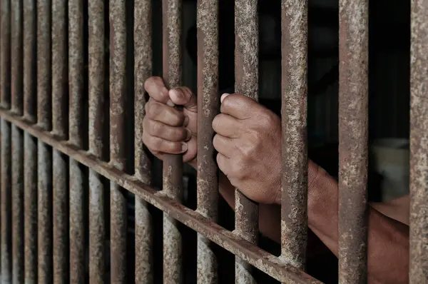 Siyah arka planda bir mahkumun elleri