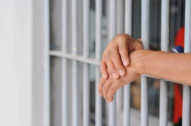 Siyah arka planda bir mahkumun elleri