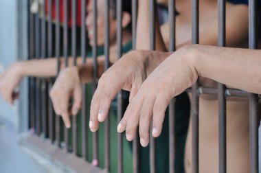 Siyah arka planda bir mahkumun elleri