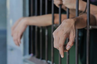 Siyah arka planda bir mahkumun elleri