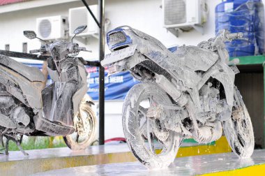 Riau-Endonezya, 10 Mart 2025: Motosiklet yıkayan bir adam