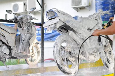 Riau-Endonezya, 10 Mart 2025: Motosiklet yıkayan bir adam