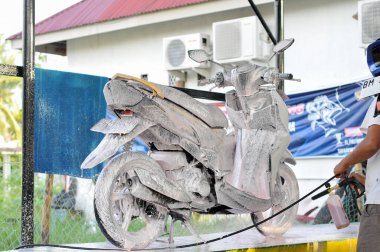 Riau-Endonezya, 10 Mart 2025: Motosiklet yıkayan bir adam