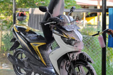 Riau-Endonezya, 10 Mart 2025: Motosiklet yıkayan bir adam