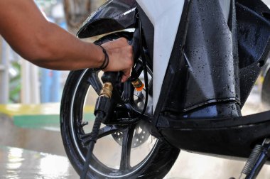 Riau-Endonezya, 10 Mart 2025: Motosiklet yıkayan bir adam