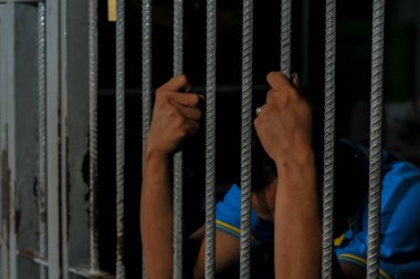 Siyah arka planda bir mahkumun elleri