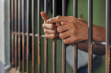 Siyah arka planda bir mahkumun elleri