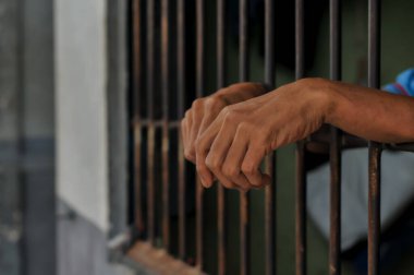 Siyah arka planda bir mahkumun elleri