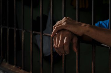 Siyah arka planda bir mahkumun elleri