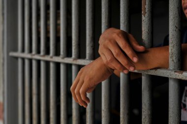 Siyah arka planda bir mahkumun elleri