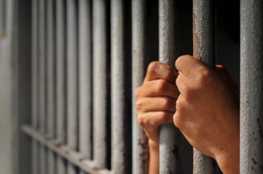 Siyah arka planda bir mahkumun elleri