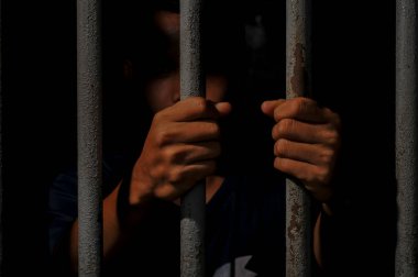 Siyah arka planda bir mahkumun elleri