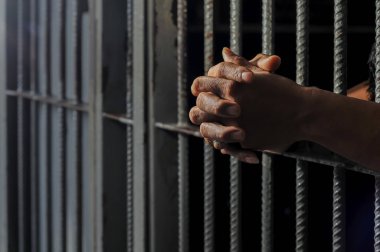 Siyah arka planda bir mahkumun elleri