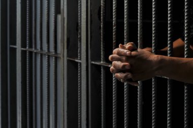 Siyah arka planda bir mahkumun elleri