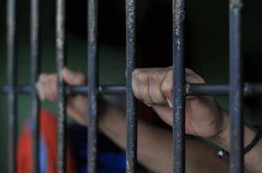 Siyah arka planda bir mahkumun elleri
