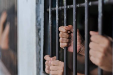 Siyah arka planda bir mahkumun elleri