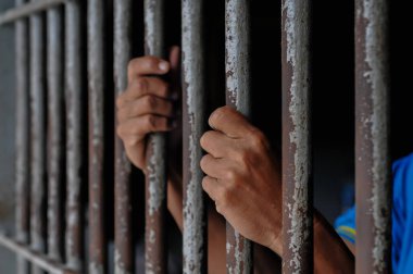 Siyah arka planda bir mahkumun elleri