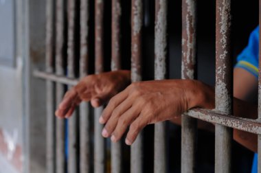 Siyah arka planda bir mahkumun elleri