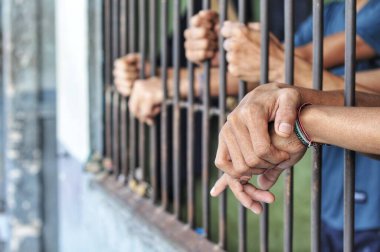 Siyah arka planda bir mahkumun elleri