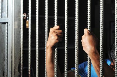 Siyah arka planda bir mahkumun elleri