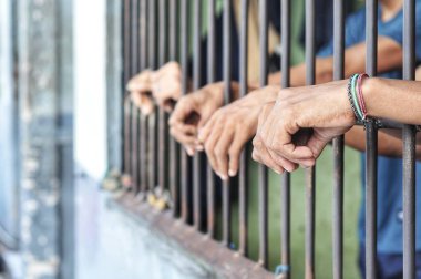 Siyah arka planda bir mahkumun elleri