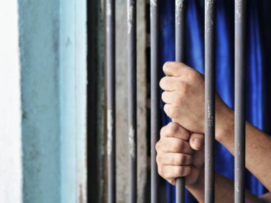 Siyah arka planda bir mahkumun elleri