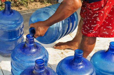 İçme suyu galonlarından içme suyu aktarılıyor.