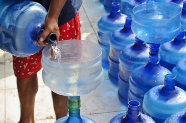 İçme suyu galonlarından içme suyu aktarılıyor.