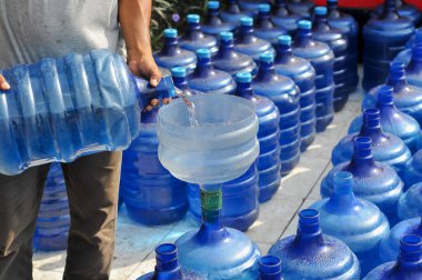 İçme suyu galonlarından içme suyu aktarılıyor.