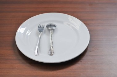 beyaz seramik tabak, çatal ve kaşıklar