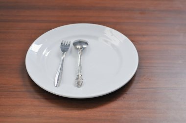 beyaz seramik tabak, çatal ve kaşıklar