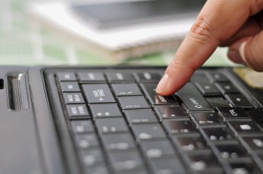 Bir kadının elleri dizüstü bilgisayarda klavyeye yazı yazıyor. Seçici odak, hareket eden parmakları vurguluyor, dinamik ve profesyonel bir his yaratıyor. Bulanık arkaplan görsel derinlik sağlar