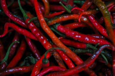 Vibrant Close-up Texture of Fresh Red Curly Chili Peppers Piled High in a Traditional Market
