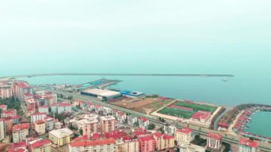 Merkez, Rize, Türkiye - 4 Mart 2024 'te kentin deniz manzaralı, hareketli şehir ana yolu ve sakin sahil yakasının kuş bakışı görüntüsü