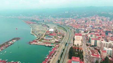 Merkez, Rize, Türkiye - 4 Mart 2024 'te Hışırdayan Şehir Ana Yolu ve Huzurlu Sahil Yakası' na Kuş Gözü Bakışı Liman ve otoyolu olan bir şehrin havadan görüntüsü
